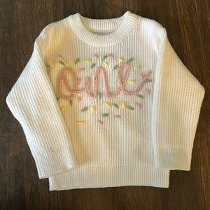 White “one” sweater for baby’s first birthday